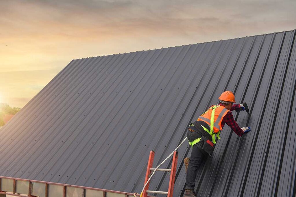 Insulated attic beneath a sloped roof with ventilation openings and sunlight across the rafters.